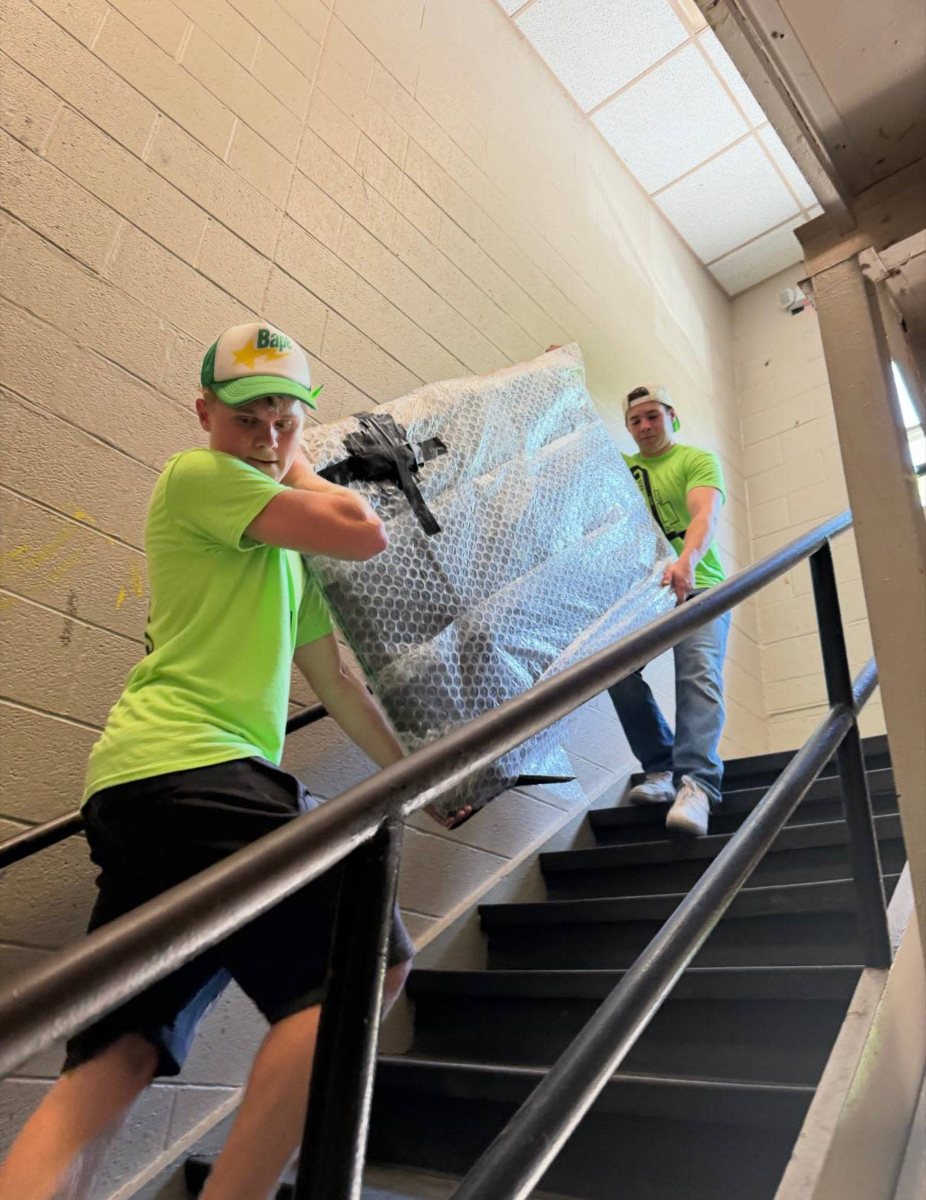 Carrying a wrapped mattress up a stairwell on a moving job